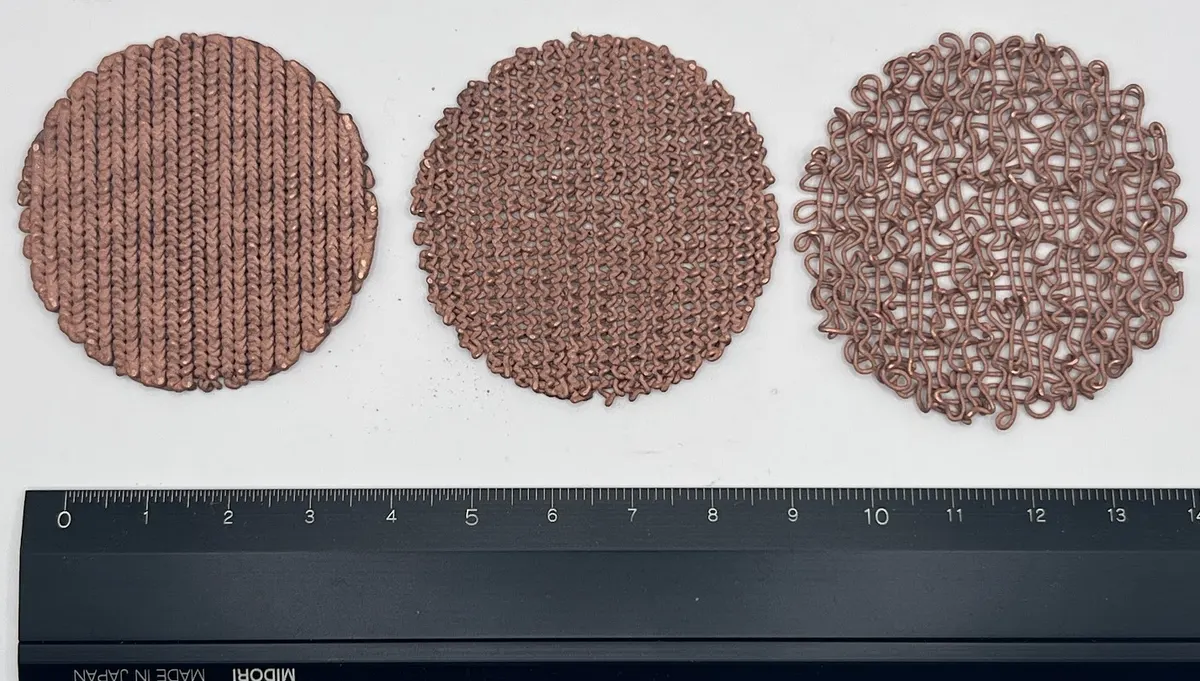 Printed copper foam discs with three different pore structures next to a ruler